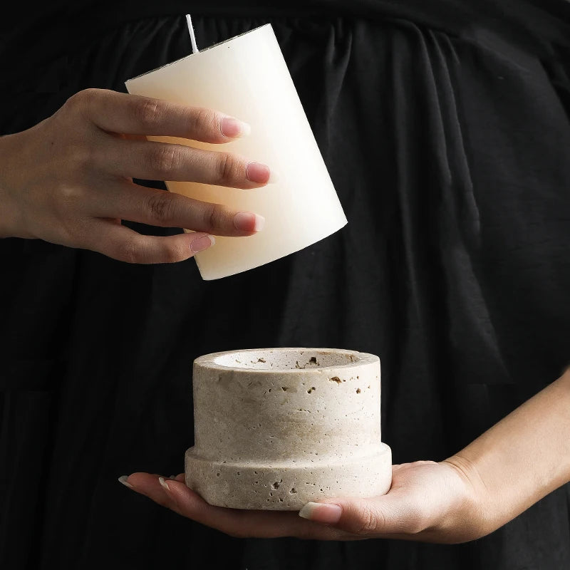 Hænder der holder travertin-lysestage — Bo Studio