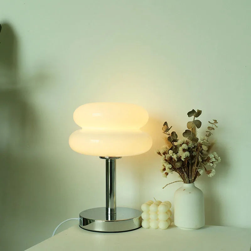 Macaron glasbordlampe i ravfarvet glas tændt i blød, varm hvid tone – stylet med eukalyptus og keramikvase – Bo Studio
