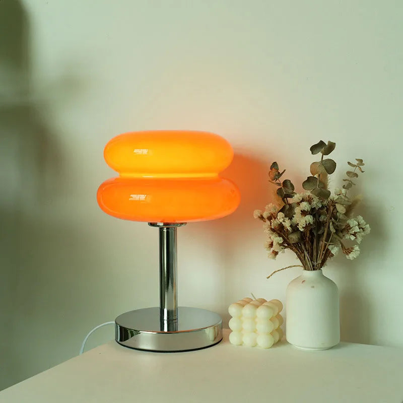 Macaron glasbordlampe i ravfarvet glas tændt med varmt, dæmpet stemningslys – stylet med tørrede grene – Bo Studio